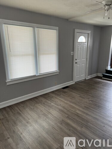 A room with wooden flooring and a white door.