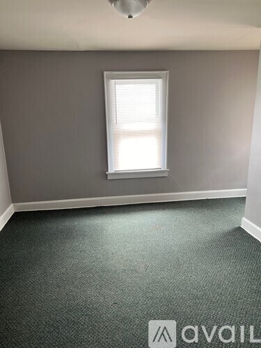 A room with a carpeted floor and a window.