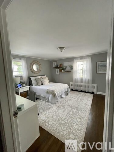 A bedroom with a bed, nightstand, and window.