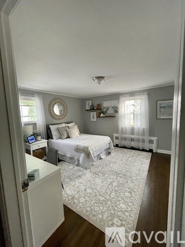 A bedroom with a bed, nightstand, and window.