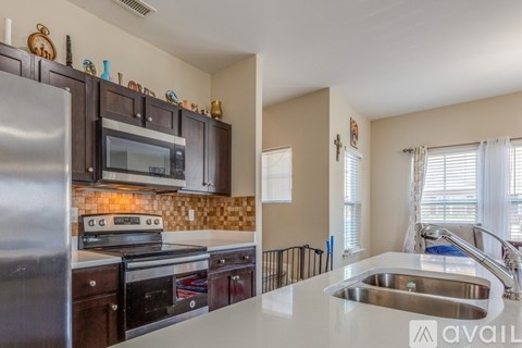 A kitchen with a stainless steel refrigerator and a tiled backsplash.