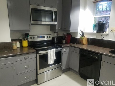 A modern kitchen with a stove top oven and microwave above it.