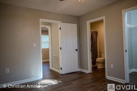 A room with a white door and a toilet in it.
