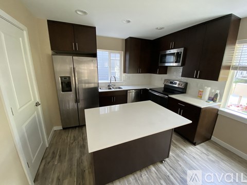 A kitchen with brown cabinets and a white island.