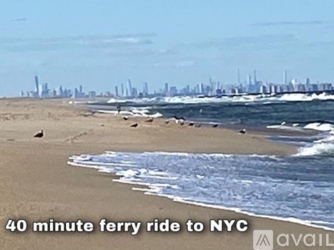 A beach with a city skyline in the background and a text that says "40 minute ferry ride to NYC".