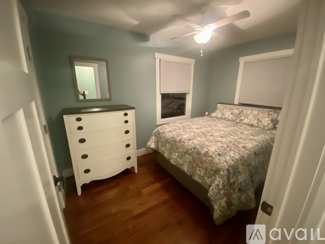 A bedroom with a bed, dresser, and mirror.