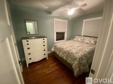 A bedroom with a bed, dresser, and mirror.