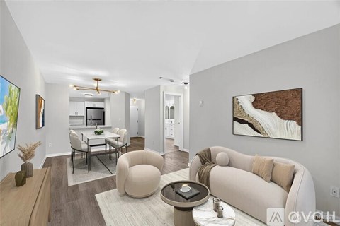 A modern living room with a large couch, a coffee table, and a painting on the wall.