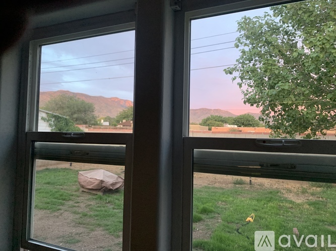 A view from a window looking out to a landscape with a mountain in the distance.