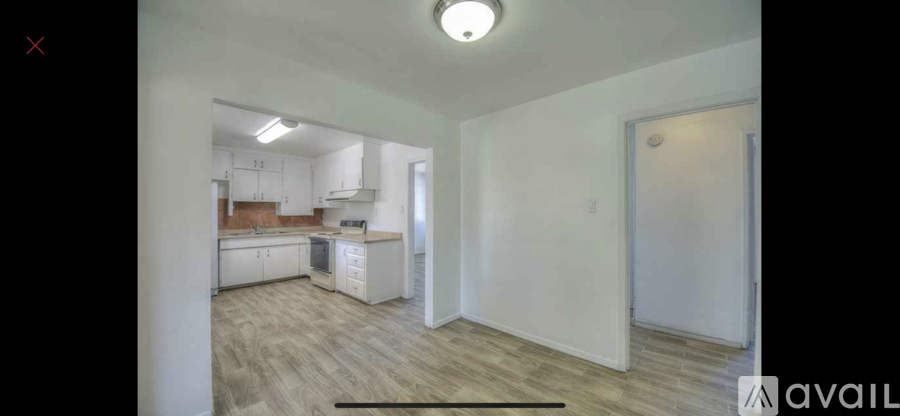A kitchen with white cabinets and a wooden floor.