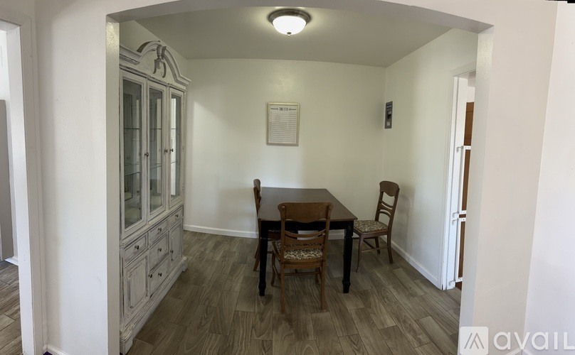 A dining room with a wooden table and chairs.