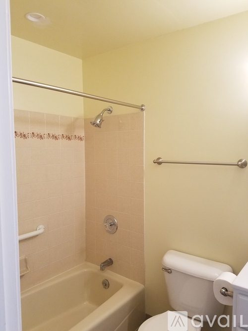 A bathroom with a tub, toilet and shower.