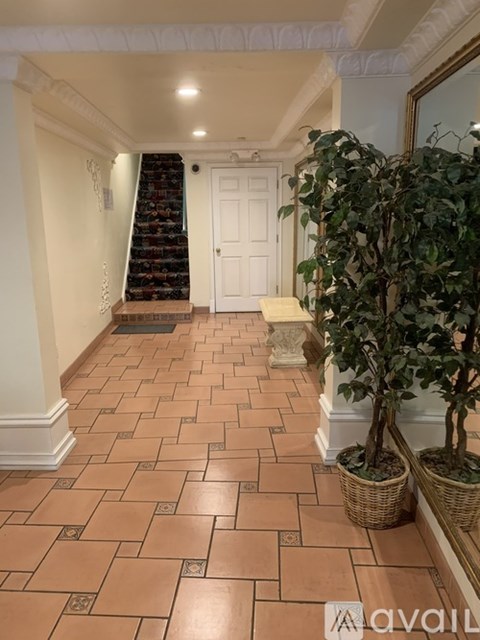 A hallway with a tiled floor and a staircase.