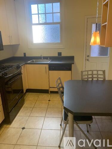 A kitchen with a table and chairs in front of a window.