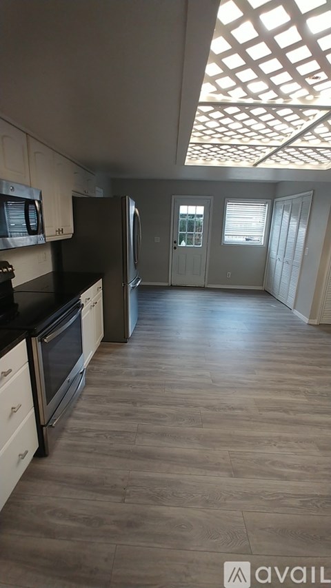 A kitchen with wooden floors and a skylight.