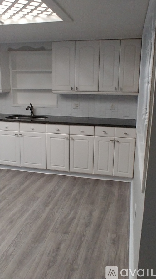 A kitchen with white cabinets and a sink.