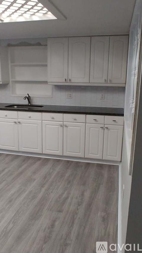 A kitchen with white cabinets and a sink.