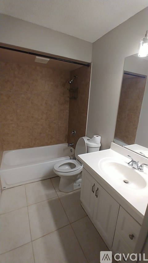 A bathroom with a toilet, sink, and mirror.