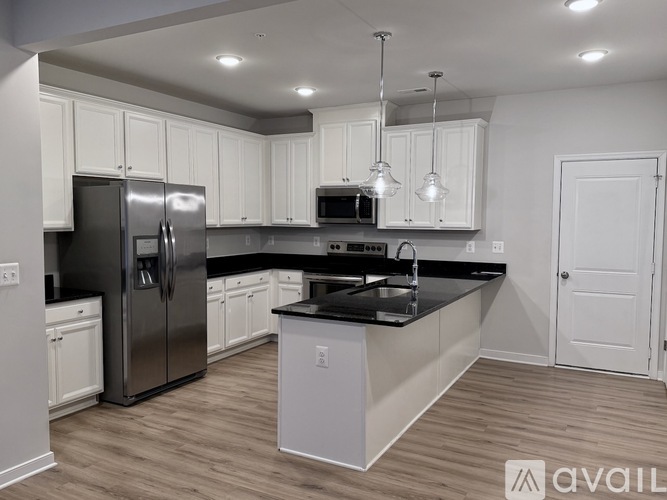 A modern kitchen with stainless steel appliances and white cabinets.