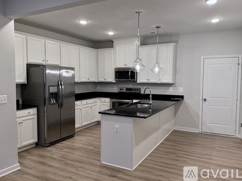 A modern kitchen with stainless steel appliances and white cabinets.