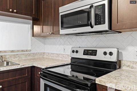 A modern kitchen with a black stove top oven and a white microwave above it.