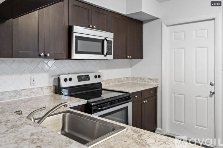 A kitchen with brown cabinets and a white door.