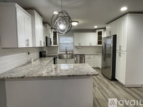 A modern kitchen with granite countertops and stainless steel appliances.