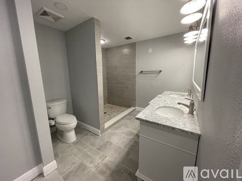 A bathroom with a toilet, sink, and shower.
