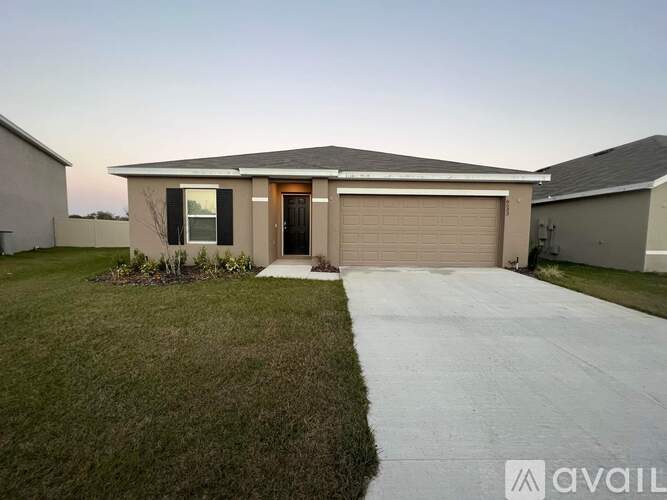 A house with a garage and a driveway is available for sale.