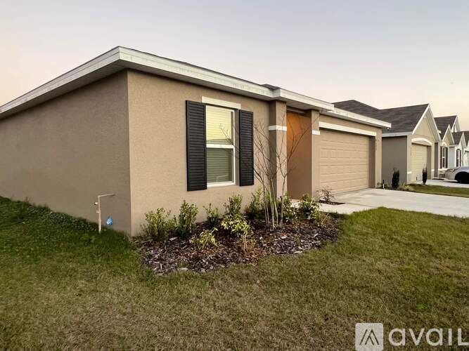 A house with a brown exterior and a small garden in front.