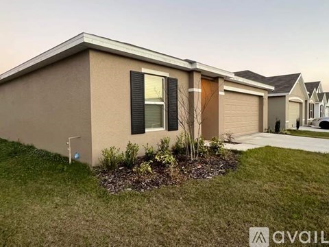 A house with a brown exterior and a small garden in front.