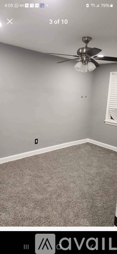 A room with a ceiling fan and carpeted floor.