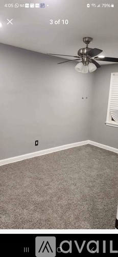 A room with a ceiling fan and carpeted floor.