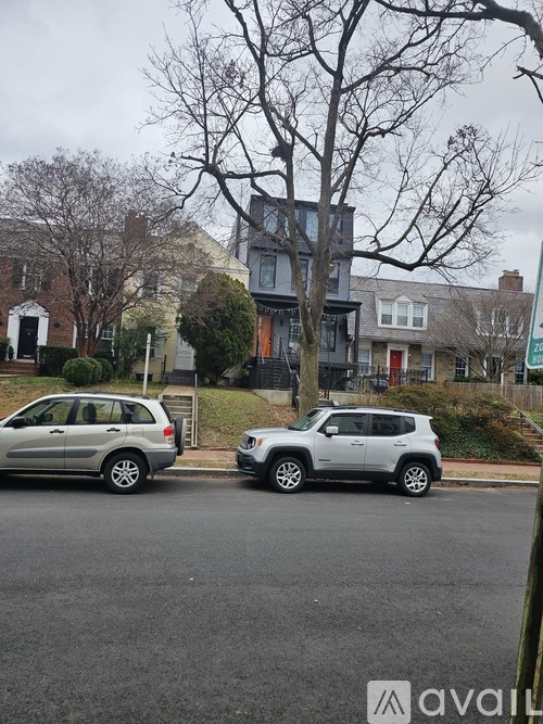 Two cars parked on a street with a building in the background.