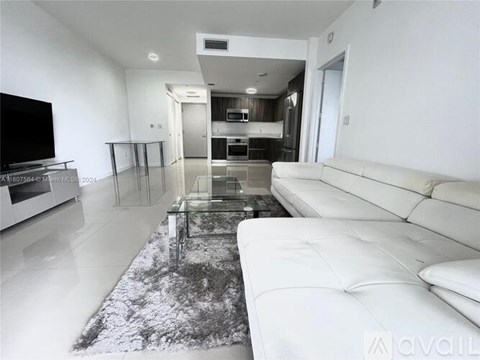 A modern living room with a white couch and a black and white rug.