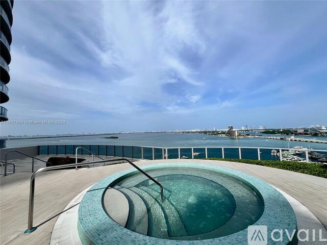 A modern outdoor pool area with a view of the water.