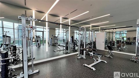 A gym with various exercise equipment and a glass wall.