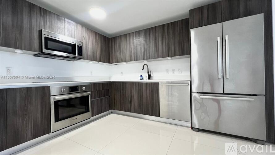 A modern kitchen with a stainless steel refrigerator and wooden cabinets.