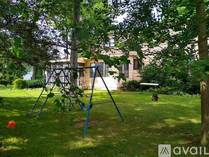 A swing set is in the middle of a grassy area.