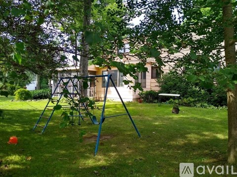 A swing set is in the middle of a grassy area.