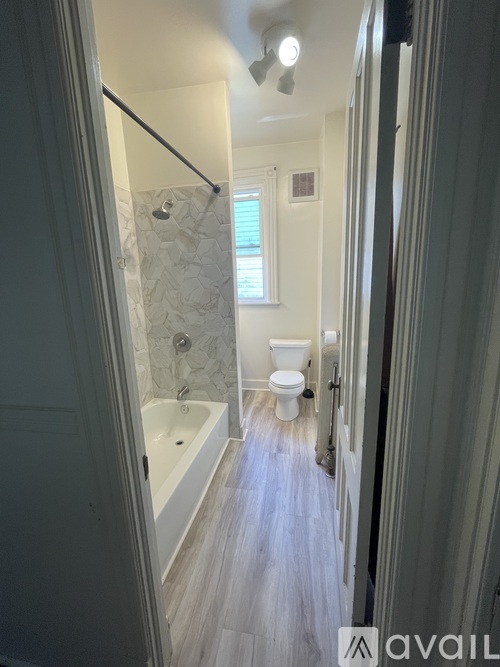A bathroom with a toilet, tub, and shower.
