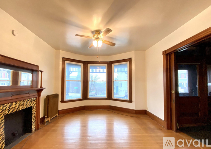 A living room with a fireplace and a ceiling fan.