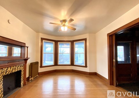A living room with a fireplace and a ceiling fan.
