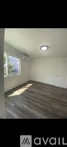A room with a wooden floor and a window.
