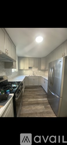 A kitchen with a stove top oven and a refrigerator.