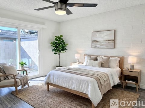 A bedroom with a large bed and a ceiling fan.