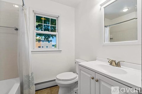 A white bathroom with a toilet, sink, and bathtub.