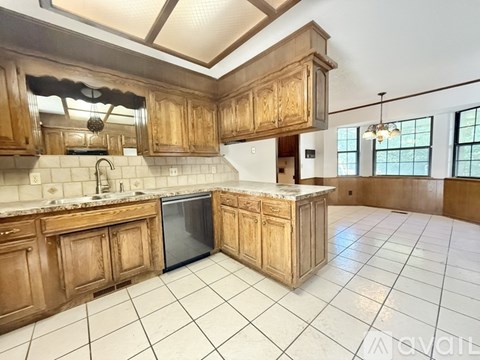 A kitchen with wooden cabinets and a marble countertop.