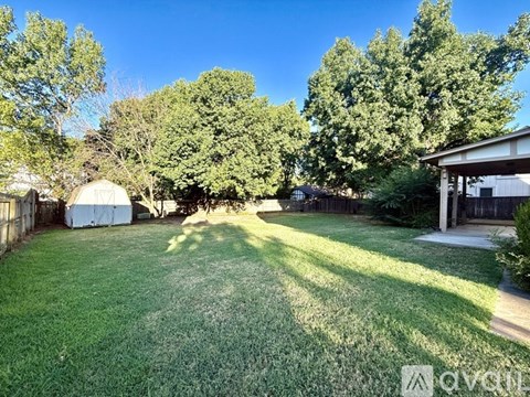 A backyard with a lawn and trees.