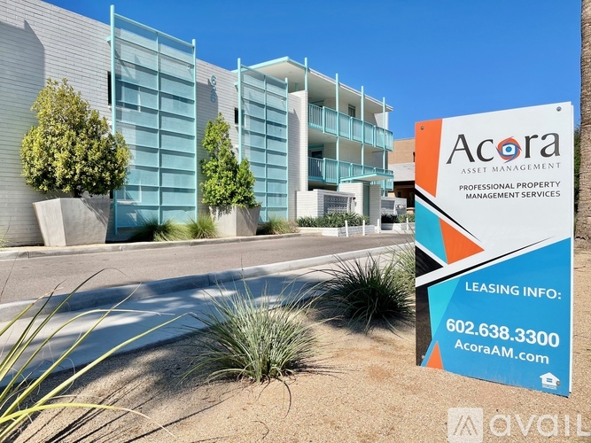 A modern building with a sign for Acora Asset Management in front of it.